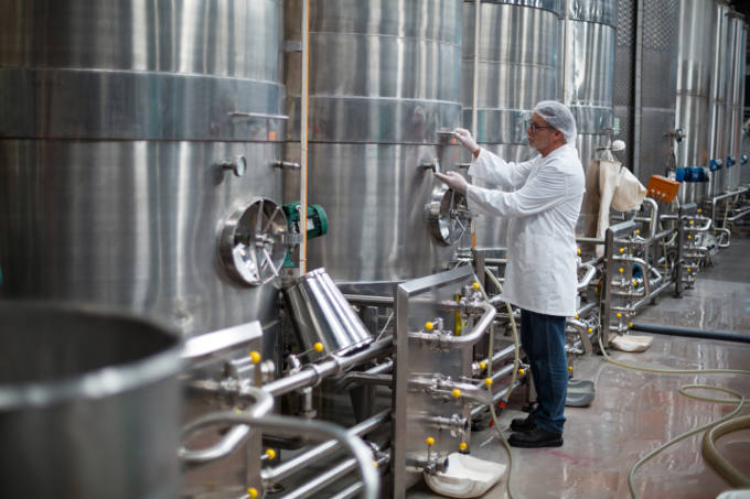 Factory engineer monitoring a pressure gauge of a storage tank